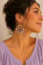 Load image into Gallery viewer, Model wearing Autumn Wings hand-painted wooden earrings with a soft lavender blouse and hair pulled back.