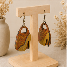 Load image into Gallery viewer, Angled view of Bag & Heels 3D wooden earrings on a light wood stand, showing the layered construction.