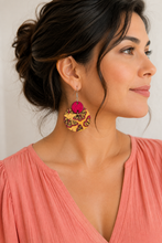 Load image into Gallery viewer, Model wearing hand-painted butterfly wooden earrings with a soft coral top, showing realistic scale.