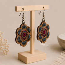 Load image into Gallery viewer, Crimson Roots embroidered wooden earrings shown at an angle to highlight their approximately 2.5 mm thickness.