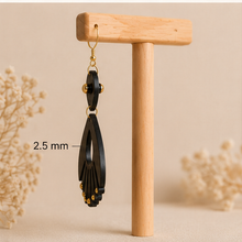 Load image into Gallery viewer, Side view of Ebony Moon wooden earrings on a light wood stand, showing the 2.5 mm wood thickness.