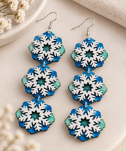 Load image into Gallery viewer, Close-up of Frozen Sky earrings showing three connected layered snowflake sections and hand-painted wood