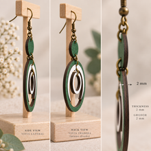 Load image into Gallery viewer, Side view of Lunar Dance articulated wooden earrings showing the 2 mm American linden wood thickness and bronze-tone hardware