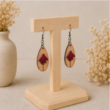 Load image into Gallery viewer, Mauve Blossom wooden earrings shown at an angle on a light wood stand, highlighting the layered floral construction.