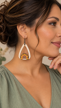 Load image into Gallery viewer, Model wearing the lightweight Sunflower Blessed wooden earring with a soft sage-green blouse, showing realistic scale and gunmetal-tone hook.