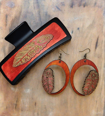 Hair clip & earring set. extraordinary hair clip, the design is a carved tribal feather cut and attached to the wood creating a three-dimensional vision.  Beside them, wooden earrings radiate vibrant, tribal energy. The expertly molded wood comes to life with a three-dimensional feather design, as if ready to take flight. Its bright colors dance with the light, catching eyes and unleashing a wave of admiration.