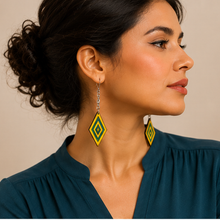Load image into Gallery viewer, Model wearing Aurora Step wooden earrings with a deep petrol blue blouse, showing the yellow and green resin design at realistic scale.
