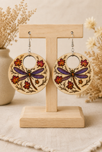 Load image into Gallery viewer, Vertical view of Autumn Wings hand-painted wooden earrings displayed on a light wood stand.
