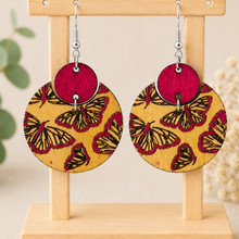 Load image into Gallery viewer, Hand-painted butterfly wooden earrings on a light wood stand with silver-tone hypoallergenic hooks.
