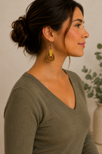 Load image into Gallery viewer, Model wearing Earth Echoes hand-painted wooden earrings with a soft olive top.
