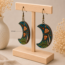 Load image into Gallery viewer, Enchanted Forest Moon wooden earrings shown from the side on a light wood stand to highlight the 2.5 mm wood thickness.
