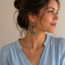 Load image into Gallery viewer, Enchanted Forest Moon wooden earring shown at realistic scale on a model wearing a soft powder-blue blouse.
