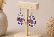 Load image into Gallery viewer, Angled view of Lavender Bloom hand-embroidered wooden earrings on a light wood stand.
