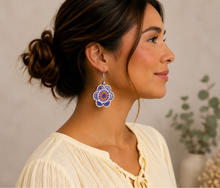 Load image into Gallery viewer, Model wearing Lavender Bloom hand-embroidered wooden earrings with a soft warm ivory blouse.
