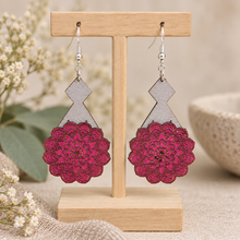 Load image into Gallery viewer, Mystic Mandala Bloom layered wooden earrings displayed front-facing on a light wood stand, showing the hand-painted magenta mandalas, gray geometric bases and silver-tone hooks.
