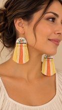 Load image into Gallery viewer, Model wearing Sun Whisper lightweight wooden earrings with hand-painted floral tops and long cream, yellow and coral macramé tassels
