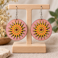 Cargar imagen en el visor de la galería, Sunheart layered hand-painted wooden sun earrings on a light wood stand with silver-tone hypoallergenic hooks
