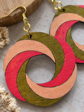 Load image into Gallery viewer, Close-up of SunTwist Joy wooden earrings showing visible wood grain, hand-painted brushstrokes, coral, peach and olive colors, and gold-tone hooks
