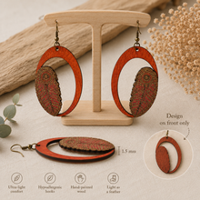 Load image into Gallery viewer, Tribal Feather lightweight wooden earrings on a light wood stand, showing 1.5 mm thickness and that the decorative design is on the front only.
