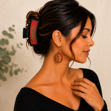 Load image into Gallery viewer, Model wearing the Tribal Feather wooden earrings with the matching large black hair clip and a simple black top.
